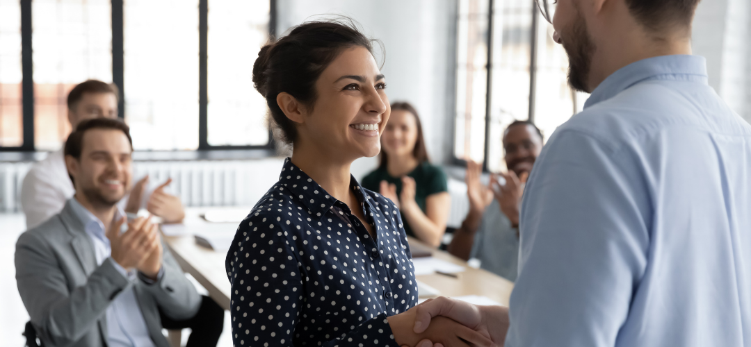 Business leader being promoted while colleagues celebrate in the background