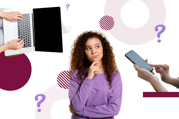 A person with curly hair stands thoughtfully with hands on chin, surrounded by a laptop and smartphone, indicating contemplation.