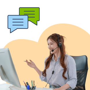 Young woman wearing headset smiling and gesturing while working at computer with chat icons above.