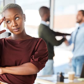 Employee who appears annoyed with two employees engaging in the background
